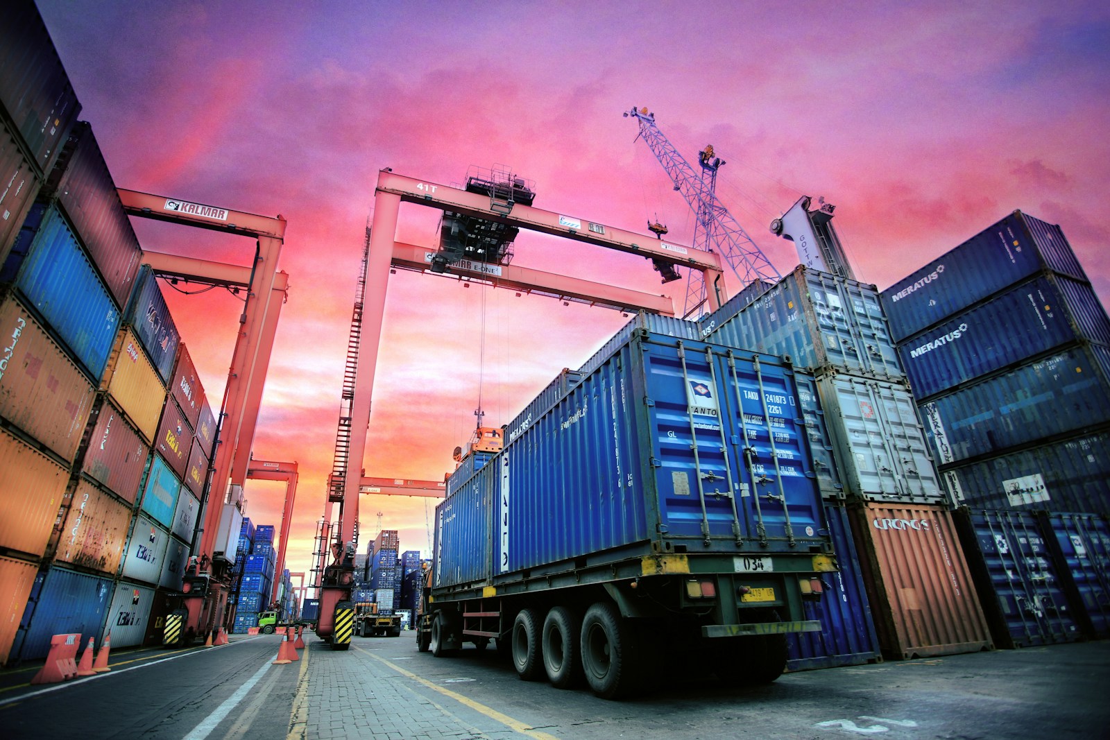 Container truck being loaded under a port gantry crane